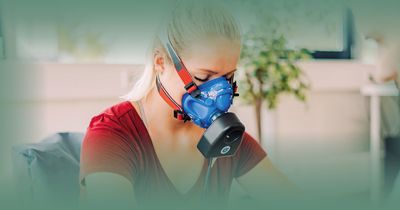 Frau macht einen Fitnesstest mit Maske auf Fahrrad