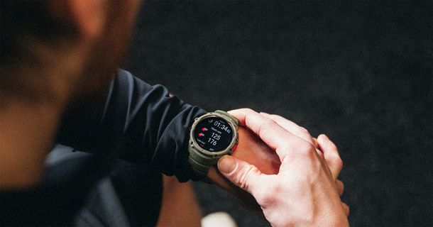 Junger Mann im Fitnessstudio prüft sein Training auf seiner Polar Street X