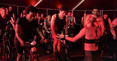 Voller Cycling-Kurs, Trainerin gibt Anweisungen an einen Teilnehmer