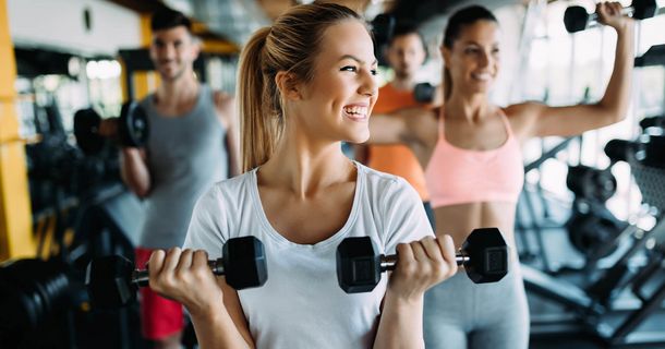Lächelnde Frau mit Hanteln im Gym