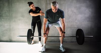 Best Ager trainiert mit Trainerin bei Luxfit an der Langhantel