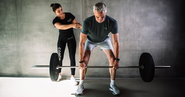 Best Ager trainiert mit Trainerin bei Luxfit an der Langhantel