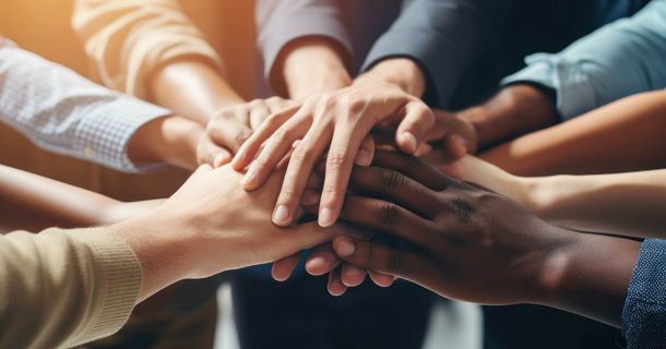 Menschen legen die Hände übereinander, um sich als Team zu bestärken