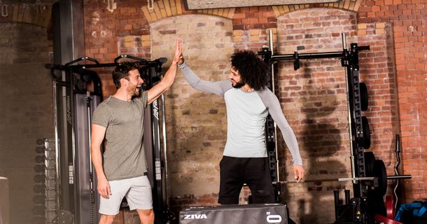 High Five im Gym von zwei Männern