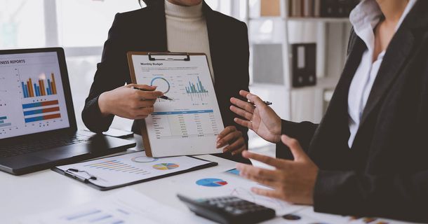 Zwei Personen in Businesskleidung prüfen Finanzzahlen