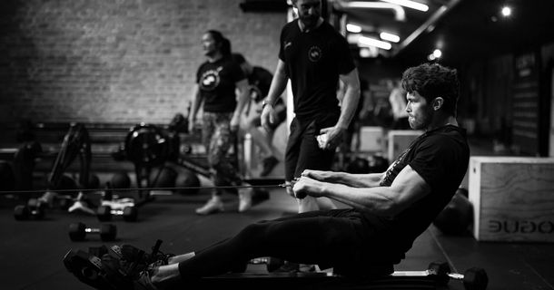 Mann auf Rudergerät beim HYROX-Training