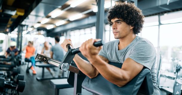 Fitnessstudiomitglied beim Training an einem Kraftgerät