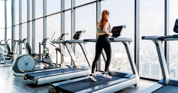 Frau läuft auf Laufband im Fitnessstudio
