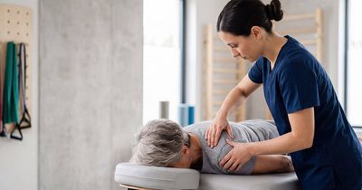 Physiotherapeutin behandelt die Schulter eines Patienten