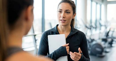 Manager im Fitnessstudio spricht mit neuem Mitarbeiter über zukünftige Aufgaben