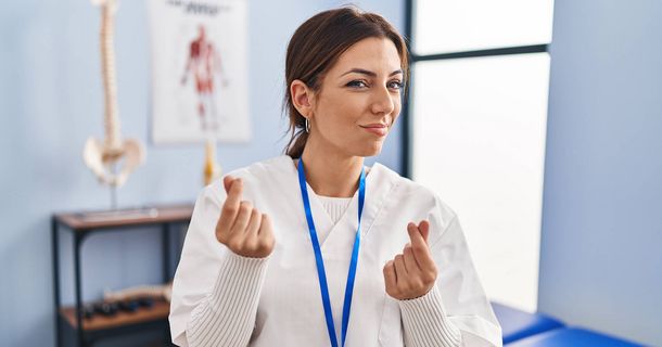 Physiotherapeutin in ihrer Praxis, die mit ihren Händen anzeigt, dass es um Geld geht