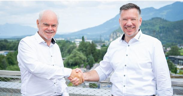 FRans Dünser und Johan Hofer (v. l.) geben sich die Hand und lächeln in die Kamera 