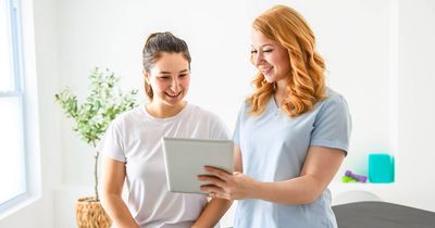 Physiotherapeut spricht mit Patientin am Tablet