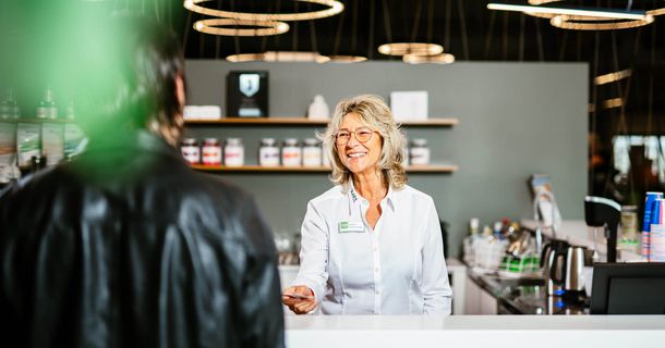 Patient spricht an der Fitnesstheke mit einer Mitarbeiterin