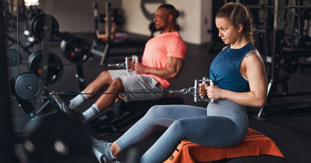 Mann und Frau trainieren in einem Fitnessstudio von FitX