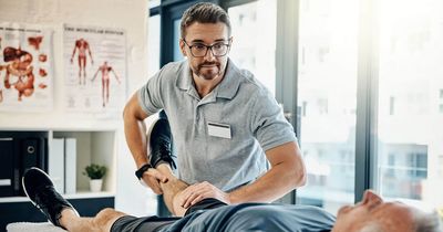 Physiotherapeut behandelt älteren Patienten am Knie