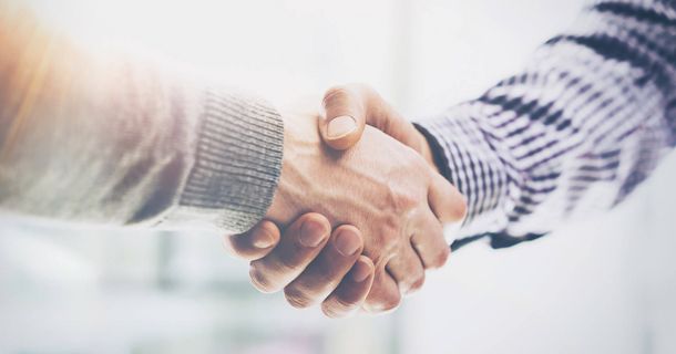 Handschlag zwischen Vertretern des IFK e.V. und Noventi zur Besiegelung der Kooperation