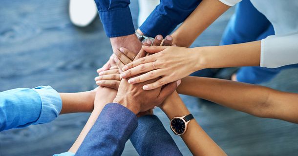 Businessleute arbeiten gemeinsam und legen die Hände übereinander
