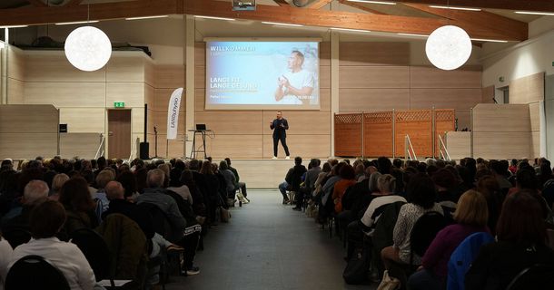 Peter Hinojal spricht beim 1. LANDphysio Gesundheitsevent auf der Bühne über Faszination Schmerzfreiheit