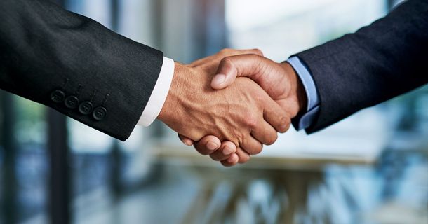 Zwei Anzugträger geben sich die Hand