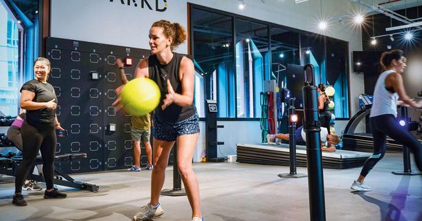 Frau fängt gelben Ball auf Trainingsfläche