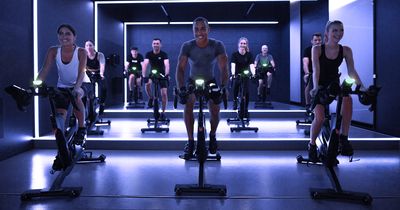Trainer und Fitnessstudiomitglieder auf Indoor Cycles