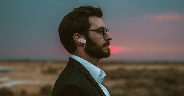 Mann mit Wearable im Ohr, das Gesundheitsdaten misst