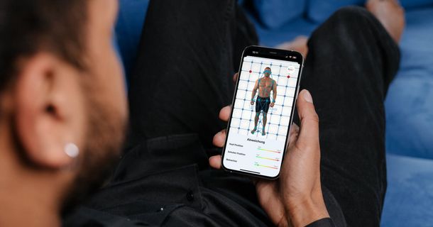 Mann schaut sich seine Physioscan-Analyse auf dem Handy an
