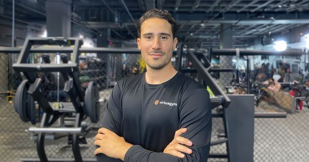 Jesús Risueño lächelt mit verschränkten Armen in die Kamera. Im Hintergrund sind Fitnessgeräte zu sehen