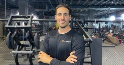 Jesús Risueño lächelt mit verschränkten Armen in die Kamera. Im Hintergrund sind Fitnessgeräte zu sehen