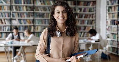 Junge Studentin vor einem Bücherregal