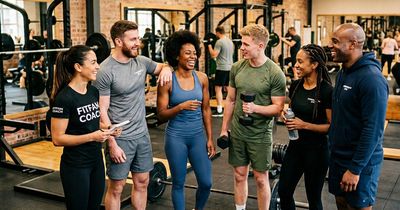 Eine fröhlich zusammenstehende Gruppe von Trainern in einem Gym