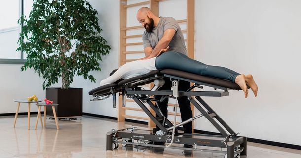Therapeut und Patient an SMART ST Therapieliege von Sport-Tec 