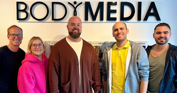 Kristian Kroth, Elisa Kroth, Nicolas Hessel, Constantin Wilser und Yannick Hessel steht im BODYMEDIA Büro vor dem BODYMEDIA Logo