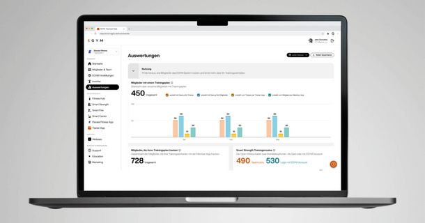 Eine Aufnahme eines geöffneten Laptops, auf dessen Bildschirm die EGYM Business Suite im Bereich "Auswertungen" angezeigt wird. Man sieht eine moderne Dashboard-Ansicht mit klaren Grafiken und Kacheln, die Statistiken zur Mitgliedernutzung von Trainingsplänen und dem Smart Strength Trainingsmodus präsentieren.