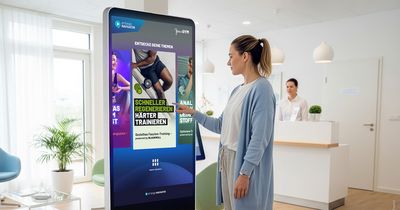 Patientin tippt etwas an einem digitalen Screen ein