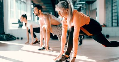 Fitnessstudiomitglieder dehnen sich auf der Trainingsfläche im Fitnessstudio