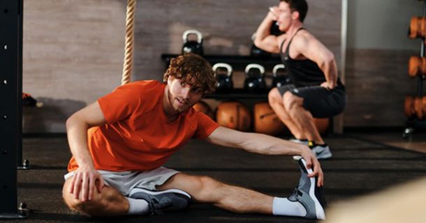 Sportler macht Dehnübungen in einem FitX Gym