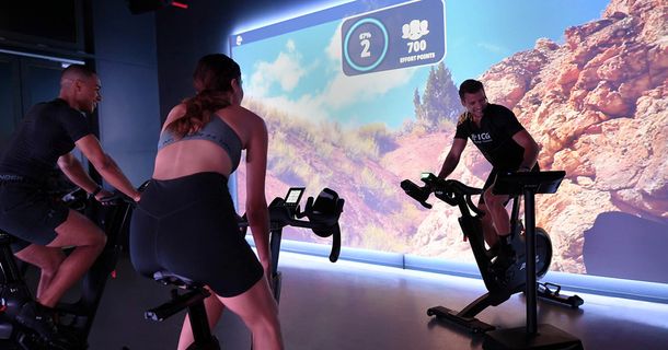 Indoor-Cycling-Kurs Trainer bedient Touchscreen