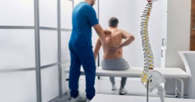 Physiotherapeut behandelt die rheumatoider Arthritis eines Patienten an der Wirbelsäule