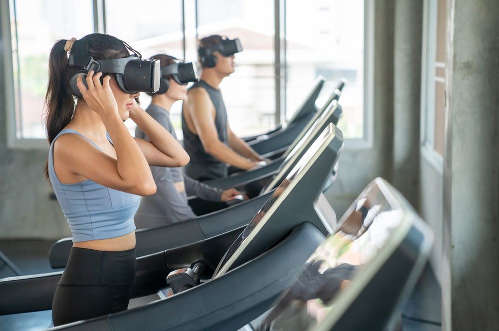 Fitnessstudiomitglieder auf Laufbändern mit Virtual-Reality-Brille
