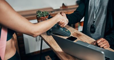 Fitnesscoach schüttelt die Hand eines Fitnessstudiomitglied