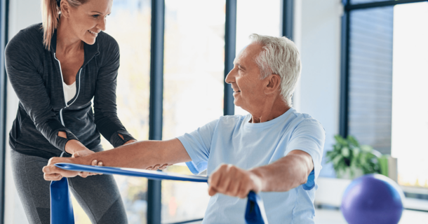 Neben einer Physiotherapeutin sitzt ein Patient mit einem 