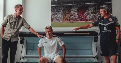 Sportdirektor Niko Bungert, Profispieler Jonathan Burkardt und Leiter Regenerations- und Prophylaxemanagement Steffen Tröster von Mainz 05 präsentieren ihr neues Ganzkörper-Rotlichtgerät (v. l.)