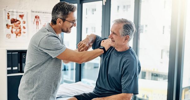 Physiotherapeut behandelt Patient an der Schulter