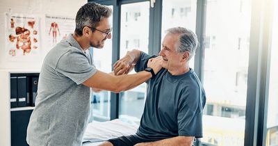 Physiotherapeut behandelt Patient an der Schulter