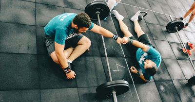 Fitnessstudiomitglieder geben sich einen Fistbump auf der Trainingsfläche