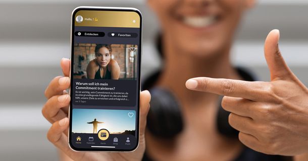 Zeigefinger zeigt auf die Nutzerfläche einer Fitness-App