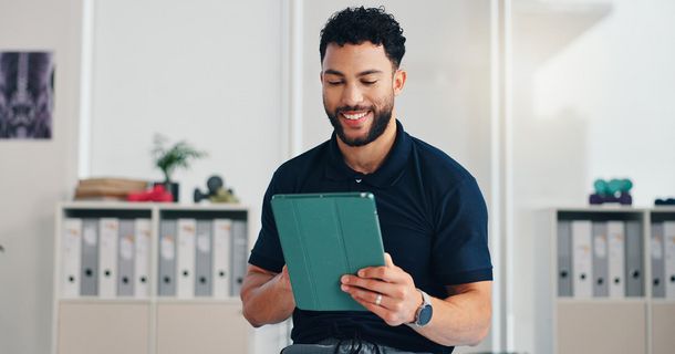 Physiotherapeut mit Tablet in der Hand in seiner Praxis