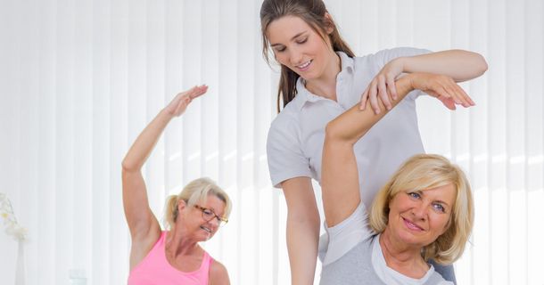 Ältere Damen beim Dehntraining der rechten Körperhälfte mit weiblichem Coach
